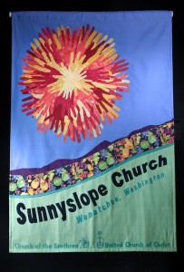 This banner representing the congregation in the Pacific Northwest Conference of the United Church of Christ, hangs in the lodge at Camp N-Sid-Sen in Idaho. The hand sun-burst is made up of hand-tracings of church participants.